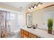 Bright bathroom with white tile, modern fixtures, and an elegant floral shower curtain at 627 Watercrest Dr, Haines City, FL 33844
