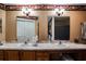 Bathroom featuring double sinks, wooden cabinets, and large mirrors for convenience at 672 Wakulla Dr, Winter Haven, FL 33884