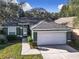 Green house with gray roof, white garage door, and walkway at 960 Old Cutler Rd, Lake Wales, FL 33898