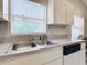 Kitchen with stainless steel sink, window overlooking outdoors, and white cabinetry at 960 Old Cutler Rd, Lake Wales, FL 33898