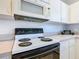 Traditional kitchen features white cabinets, matching appliances, and neutral countertops at 960 Old Cutler Rd, Lake Wales, FL 33898