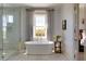 Bright bathroom featuring soaking tub, large window with curtains, and glass enclosed shower at 2300 Scenic N Hwy # 51, Lake Wales, FL 33898