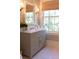 Well-lit bathroom with shaker style vanity, natural stone counters, and wallpapered walls at 2300 Scenic N Hwy # 51, Lake Wales, FL 33898