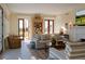Sun-filled living room with striped seating, a rustic wooden table, and views of the backyard at 2300 Scenic N Hwy # 51, Lake Wales, FL 33898