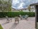 Brick patio with an outdoor dining set and a green hedge for privacy at 4189 Limerick Dr, Lake Wales, FL 33859