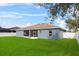 Grassy backyard featuring screened-in lanai and white vinyl fence at 2821 Sheldon St, Lakeland, FL 33813