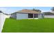 Grassy backyard with screened-in lanai and white vinyl fence at 2821 Sheldon St, Lakeland, FL 33813