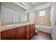 Bathroom featuring double vanity, tub-shower combo, and wooden cabinets at 2821 Sheldon St, Lakeland, FL 33813