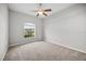 Bedroom with carpet floors, ceiling fan, and a large window overlooking the front yard at 2821 Sheldon St, Lakeland, FL 33813