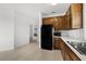 Kitchen with wooden cabinetry, black appliances, and tiled floors at 4071 Albritton Rd, St Cloud, FL 34772