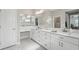 Double vanity bathroom with white cabinets and marble flooring at 473 Adams View Ln, Auburndale, FL 33823