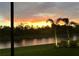 Stunning sunset view over a canal with lush landscaping at 473 Adams View Ln, Auburndale, FL 33823