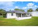 Exterior view of home features a screened in porch, solar panels, and large lawn at 105 Elliott Ln, Winter Haven, FL 33884