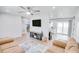 Open-concept living room with neutral decor, ceiling fan, and a modern entertainment center at 105 Elliott Ln, Winter Haven, FL 33884