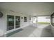 This patio features speckled floors, a white brick wall, a white ceiling, and sliding glass doors to the backyard at 105 Elliott Ln, Winter Haven, FL 33884