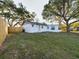 View of backyard of charming home featuring mature trees and a wooden fence at 2002 Sutton Rd, Lakeland, FL 33810