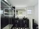 Sleek bathroom featuring a double vanity, glass shower, modern fixtures, and geometric-patterned tile floors at 2002 Sutton Rd, Lakeland, FL 33810