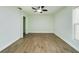 Spacious bedroom featuring modern ceiling fan, wood-look flooring, fresh paint, and natural light from the window at 2002 Sutton Rd, Lakeland, FL 33810