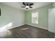 Inviting bedroom with wood-look flooring, white trim, light green paint, and a modern ceiling fan at 2002 Sutton Rd, Lakeland, FL 33810