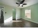 Bright bedroom featuring modern ceiling fan, wood-look flooring, fresh paint, and natural light from the window at 2002 Sutton Rd, Lakeland, FL 33810