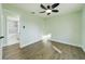 Bright bedroom featuring new floors and ceiling fan, with adjoining bathroom at 2002 Sutton Rd, Lakeland, FL 33810