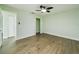 Light-filled bedroom showcasing wood-look flooring, white trim, fresh paint, and an open closet at 2002 Sutton Rd, Lakeland, FL 33810