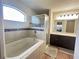 Bright bathroom featuring a soaking tub, glass shower, and dark wood vanity with marble countertop at 222 Cattail Way, Lake Alfred, FL 33850