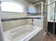 Bathroom with tiled tub and glass shower doors at 222 Cattail Way, Lake Alfred, FL 33850