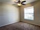 This carpeted bedroom offers a window, ceiling fan, and outlets for various electronics at 222 Cattail Way, Lake Alfred, FL 33850