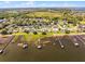 An aerial view of lakefront properties; docks and a home with green marker are featured with lake and wood views at 324 Hamilton Shores Ne Dr, Winter Haven, FL 33881