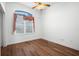 Cozy bedroom with wood floors, ceiling fan, and a window with curtains at 324 Hamilton Shores Ne Dr, Winter Haven, FL 33881