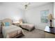 Bright bedroom featuring two twin beds, neutral carpet and white walls with a ceiling fan and natural light at 324 Hamilton Shores Ne Dr, Winter Haven, FL 33881