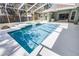 A backyard screened-in pool with clear water, blue tiles, and a white deck at 324 Hamilton Shores Ne Dr, Winter Haven, FL 33881