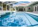 Screened-in pool featuring a built-in spa and clear blue water, backyard at 324 Hamilton Shores Ne Dr, Winter Haven, FL 33881