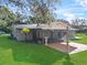 Rear view showing a screened-in porch and patio area that overlooks a lush green lawn at 4570 Chambliss Rd, Winter Haven, FL 33884