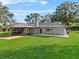 Expansive backyard featuring a screened-in porch, lush green lawn, and mature landscaping at 4570 Chambliss Rd, Winter Haven, FL 33884