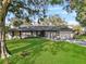 Charming single-story home with a well-manicured lawn and a two-car garage, framed by mature trees at 4570 Chambliss Rd, Winter Haven, FL 33884