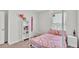 Decorated bedroom with a pink bed, shelving, and hanging chair at 935 Waterville Dr, Auburndale, FL 33823