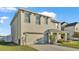 Two-story house with light beige siding, two-car garage, and a manicured lawn at 935 Waterville Dr, Auburndale, FL 33823