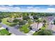 Lovely aerial view of a home on a manicured lawn with mature trees and a neighborhood street at 1591 Forest Hills Ln, Haines City, FL 33844