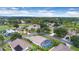 An aerial view of a neighborhood showcasing a home with a screened pool at 1591 Forest Hills Ln, Haines City, FL 33844