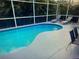 Relaxing screened-in pool area with lounge chairs and privacy landscaping at 1591 Forest Hills Ln, Haines City, FL 33844