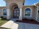Inviting front entrance with beautiful double doors, arched windows, and manicured landscaping at 2712 Oak Hammock Loop, Mulberry, FL 33860