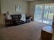 Comfortable living room with a cozy couch, neutral carpet, and a sliding glass door at 2712 Oak Hammock Loop, Mulberry, FL 33860