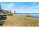 Spacious backyard with manicured lawn leading to a serene lake and private dock at 288 Hernando Rd, Winter Haven, FL 33884