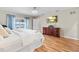 A light-filled bedroom includes hardwood floors and views of a lake in the backyard at 288 Hernando Rd, Winter Haven, FL 33884