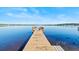 Scenic view of a private wooden dock extending into a calm lake on a sunny day with blue skies at 288 Hernando Rd, Winter Haven, FL 33884