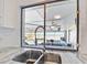 Kitchen sink with faucet overlooks screened pool and outdoor dining area at 288 Hernando Rd, Winter Haven, FL 33884
