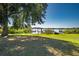 Expansive lawn with shade trees and a glimpse of the private dock and lake, offering a serene outdoor space at 4027 Island Lakes Dr, Winter Haven, FL 33881