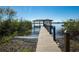 Picturesque view of a private dock extending into a tranquil lake with a covered pavilion on stilts at 4027 Island Lakes Dr, Winter Haven, FL 33881